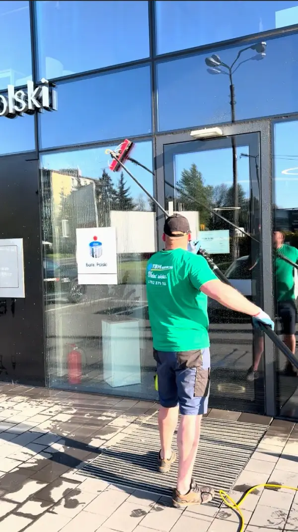 pracownik myje elewacje